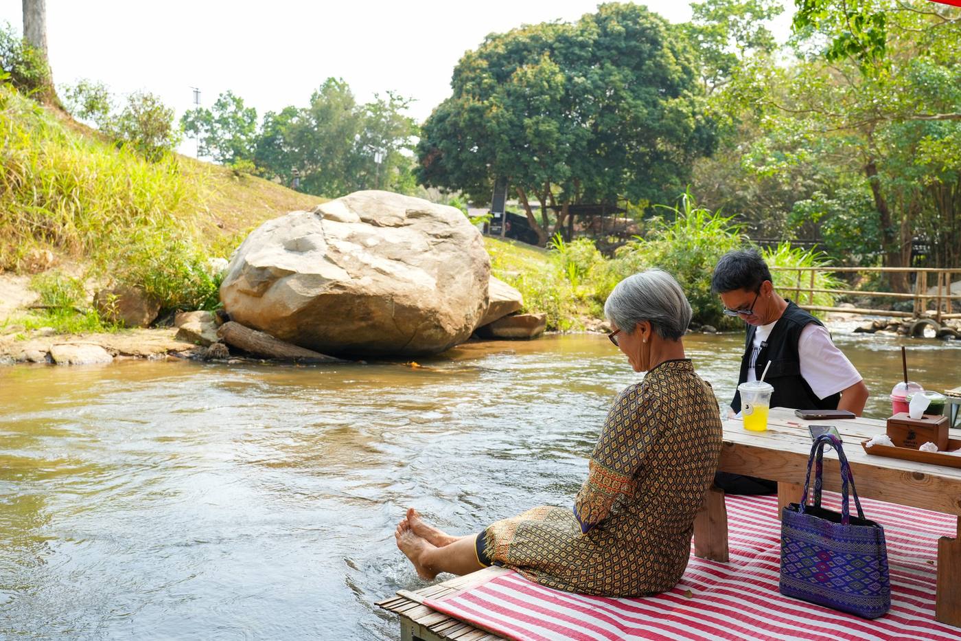ลูกค้านั่งแพหย่อนเท้าลงลำธาร ร้านริมธารา แม่ริม