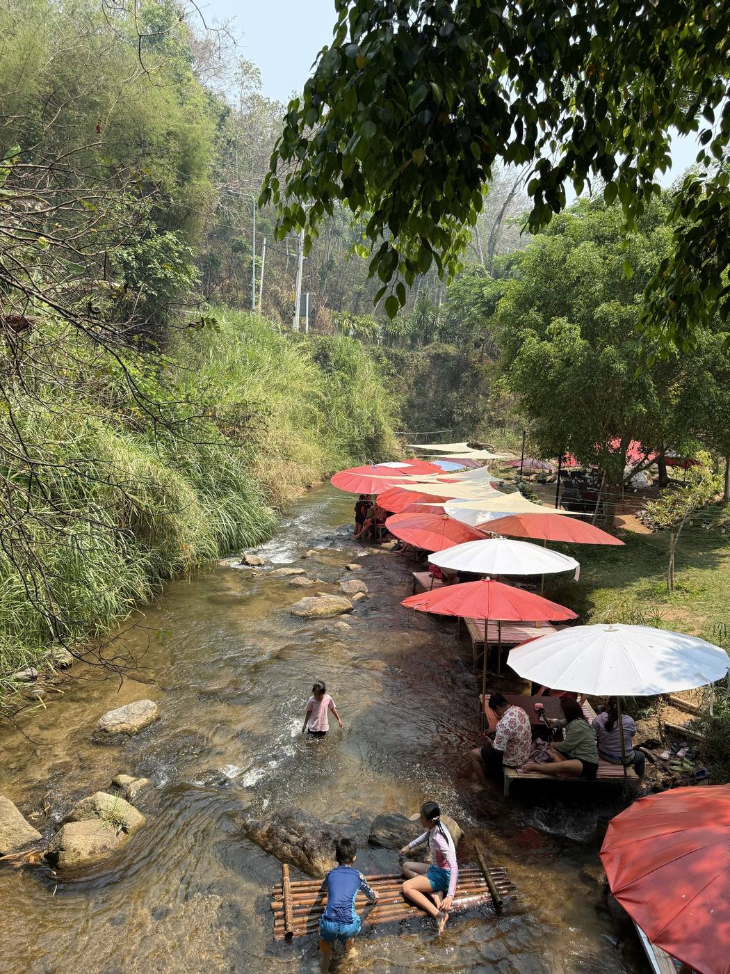 เด็กเล่นน้ำในลำธารตื้นข้างแพ ร้านอาหารครอบครัวแม่ริม